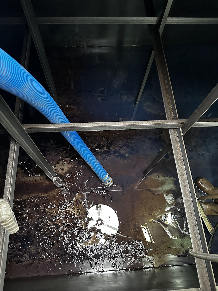 Engineer cleaning the interior of a large commercial tank